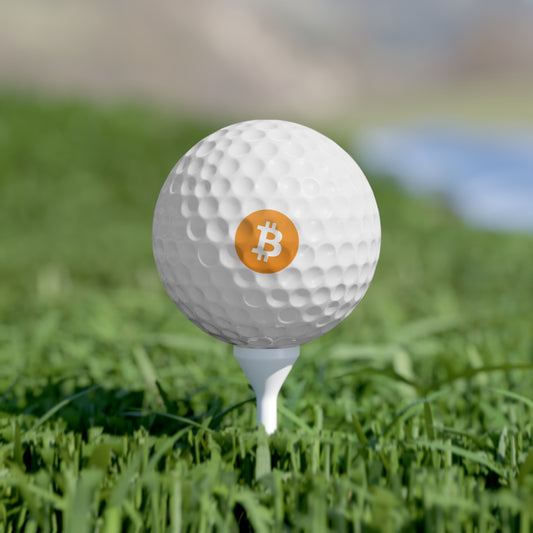 White golf ball with orange Bitcoin ₿ logo On a tee in green grass.