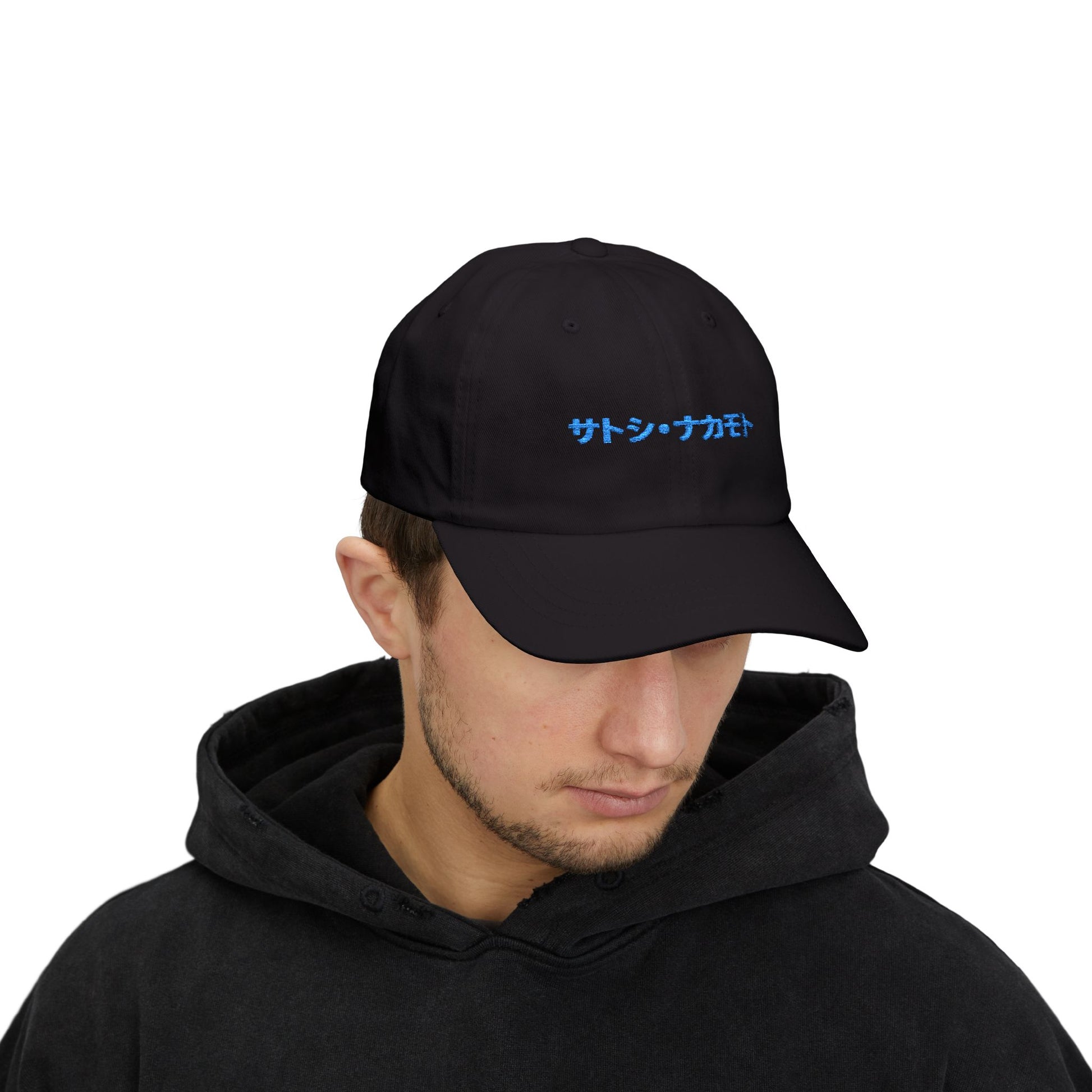 Black  hat with embroidered “サトシ・ナカモト” (Satoshi Nakamoto) in royal blue Japanese Katakana.