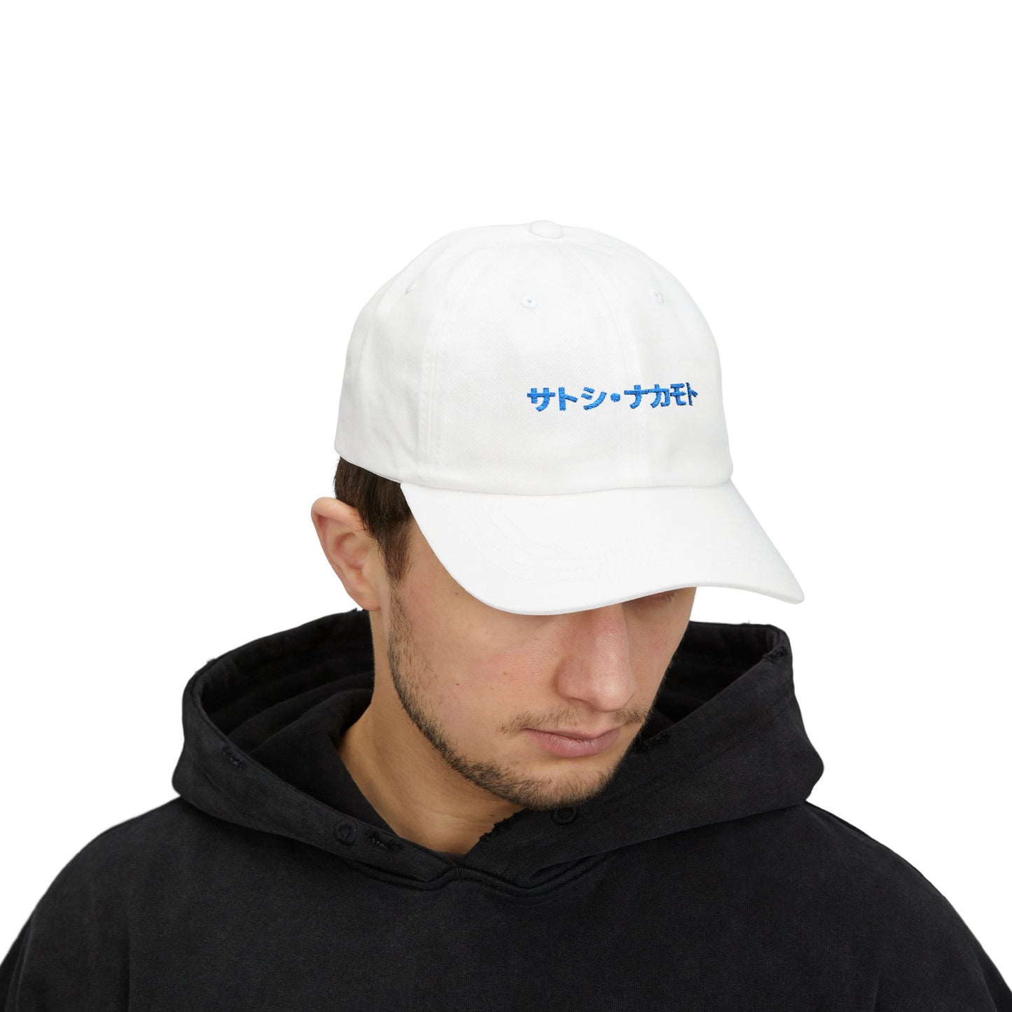 White hat with embroidered “サトシ・ナカモト” (Satoshi Nakamoto) in royal blue Japanese Katakana.